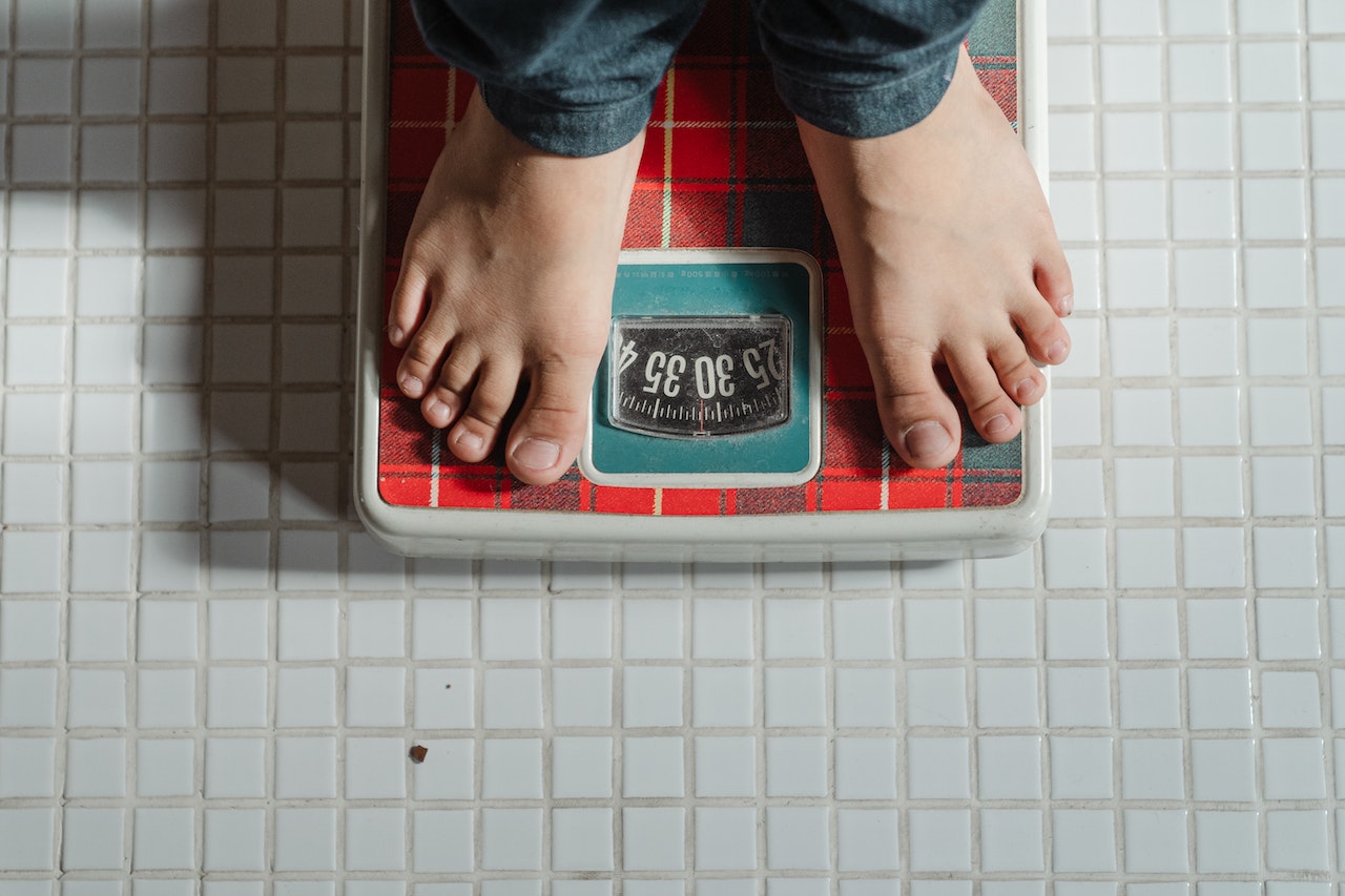 kid weighing himself on scale