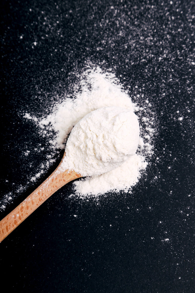 creatine powder in a wooden spoon