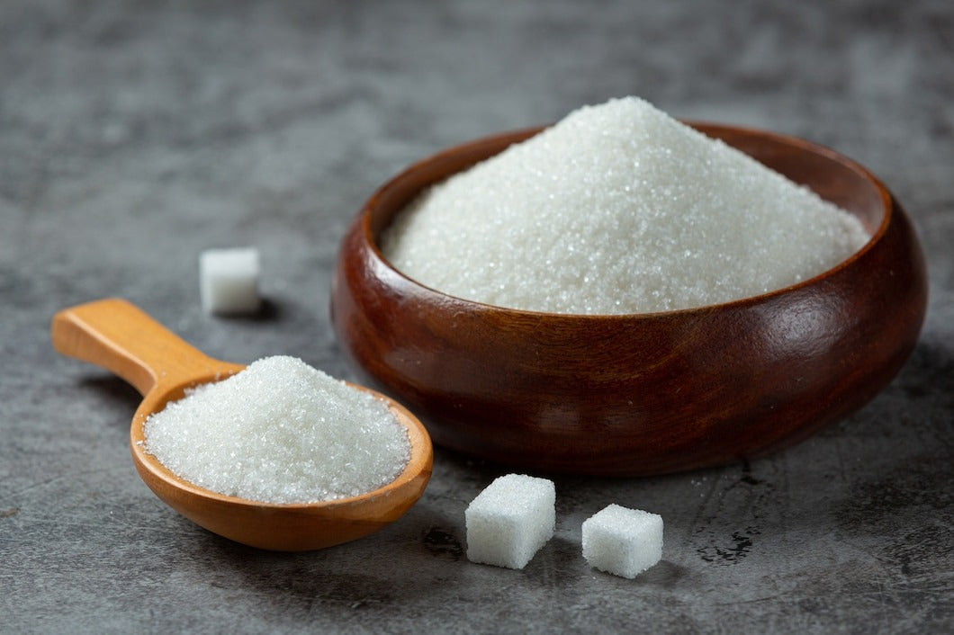 sugar in wooden bowl on dark surface